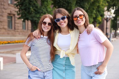 Photo of Portrait of happy friends in sunglasses outdoors