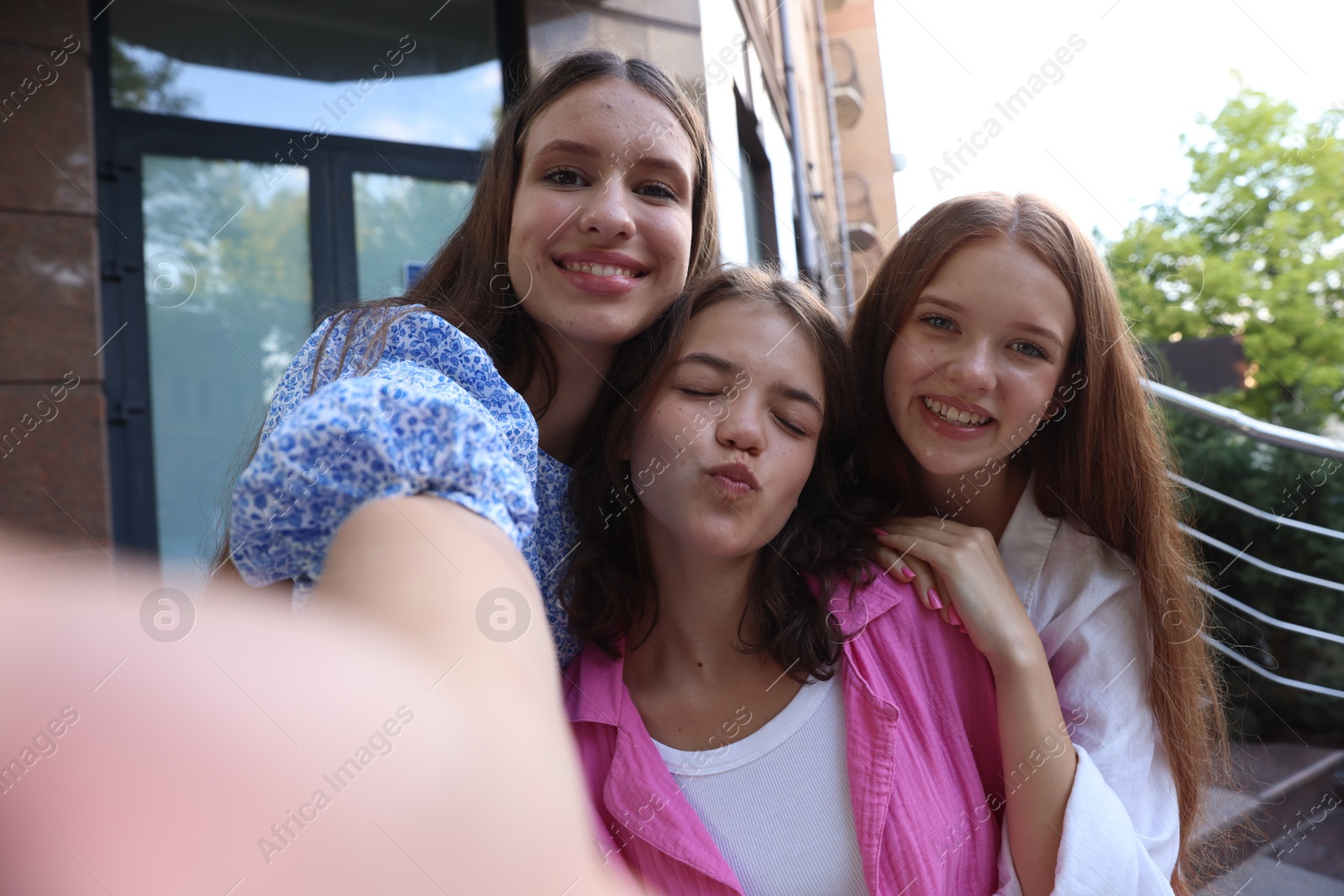 Photo of Happy friends taking selfie on city street