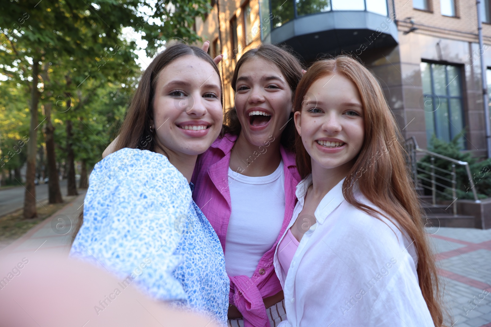 Photo of Happy friends taking selfie on city street