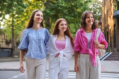 Photo of Happy friends walking together on city street