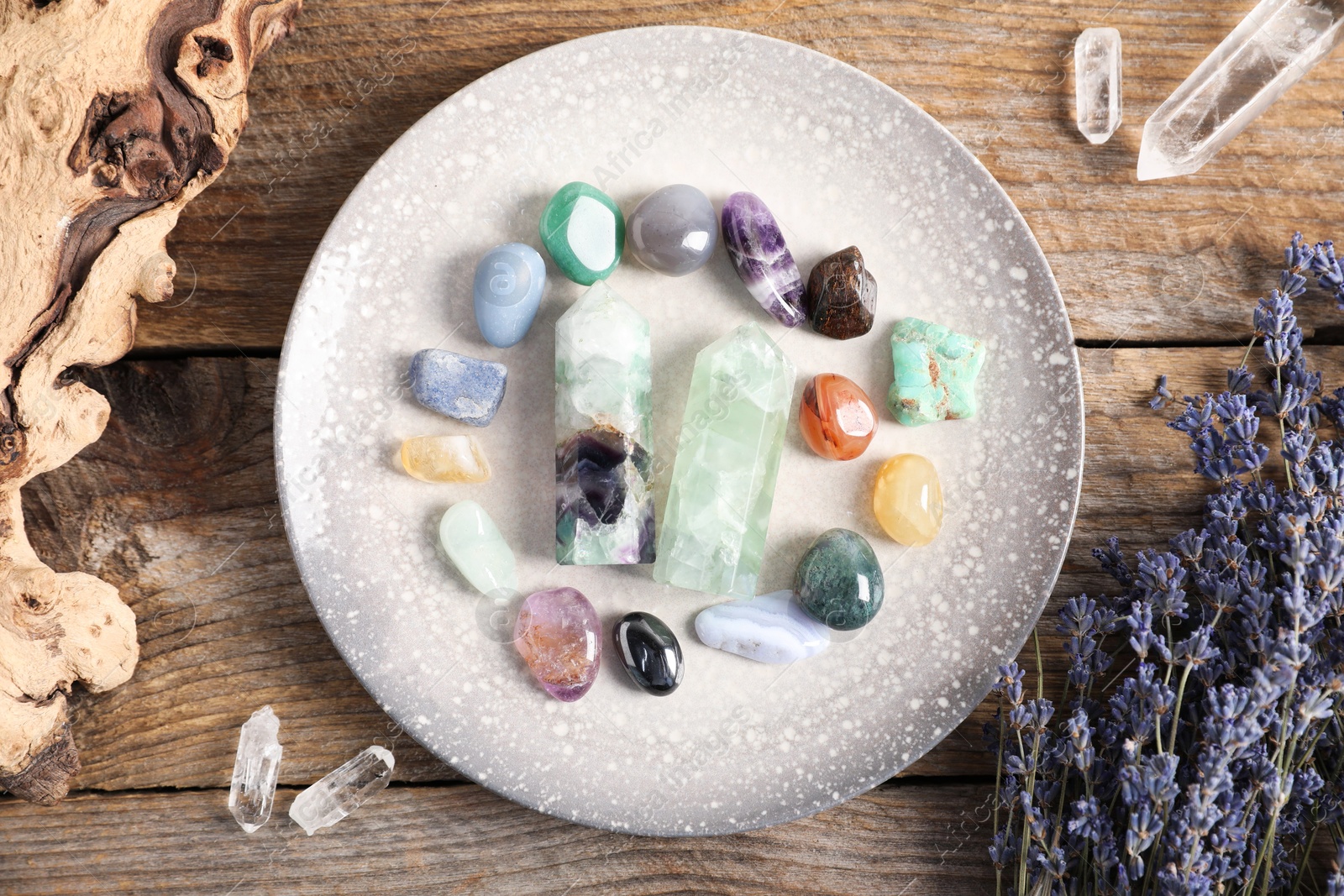 Photo of Aura. Different natural mineral stones, lavender and snag on wooden table, flat lay