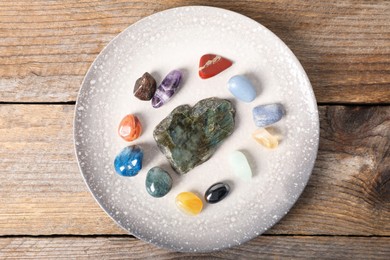 Photo of Aura. Different natural mineral stones on wooden table, top view