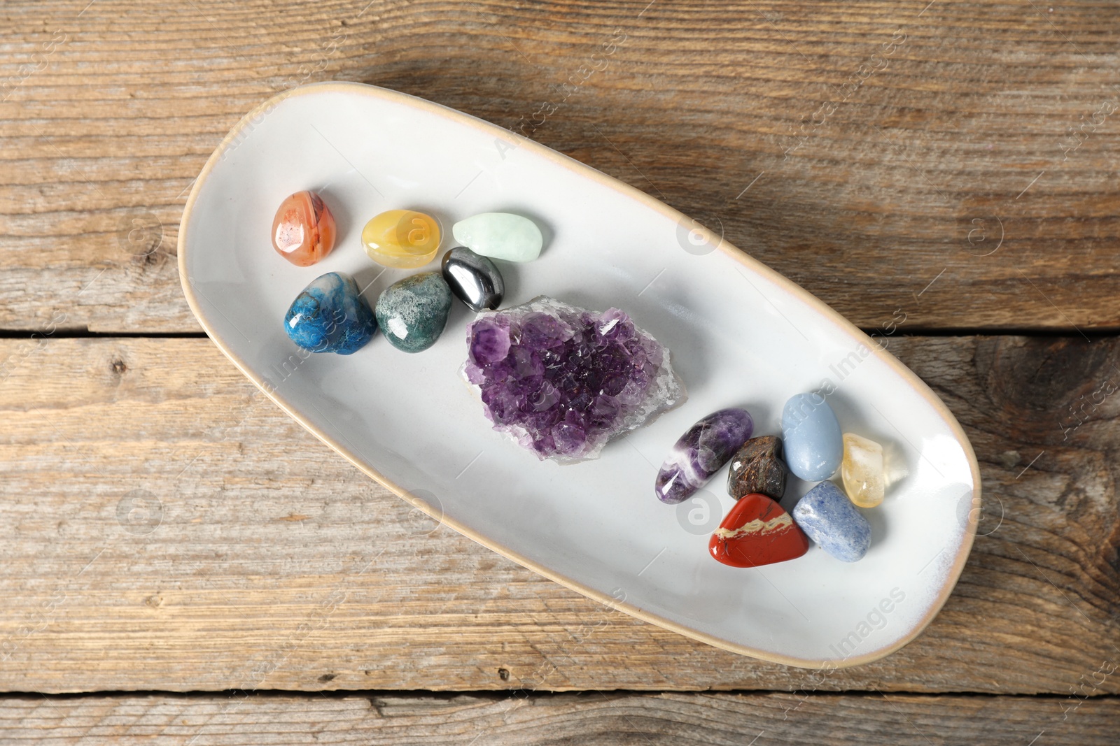 Photo of Aura. Different natural mineral stones on wooden table, top view