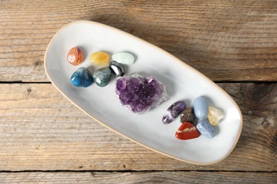 Photo of Aura. Different natural mineral stones on wooden table, top view