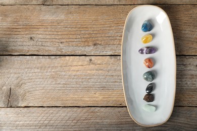 Photo of Aura. Different natural mineral stones on wooden table, top view. Space for text
