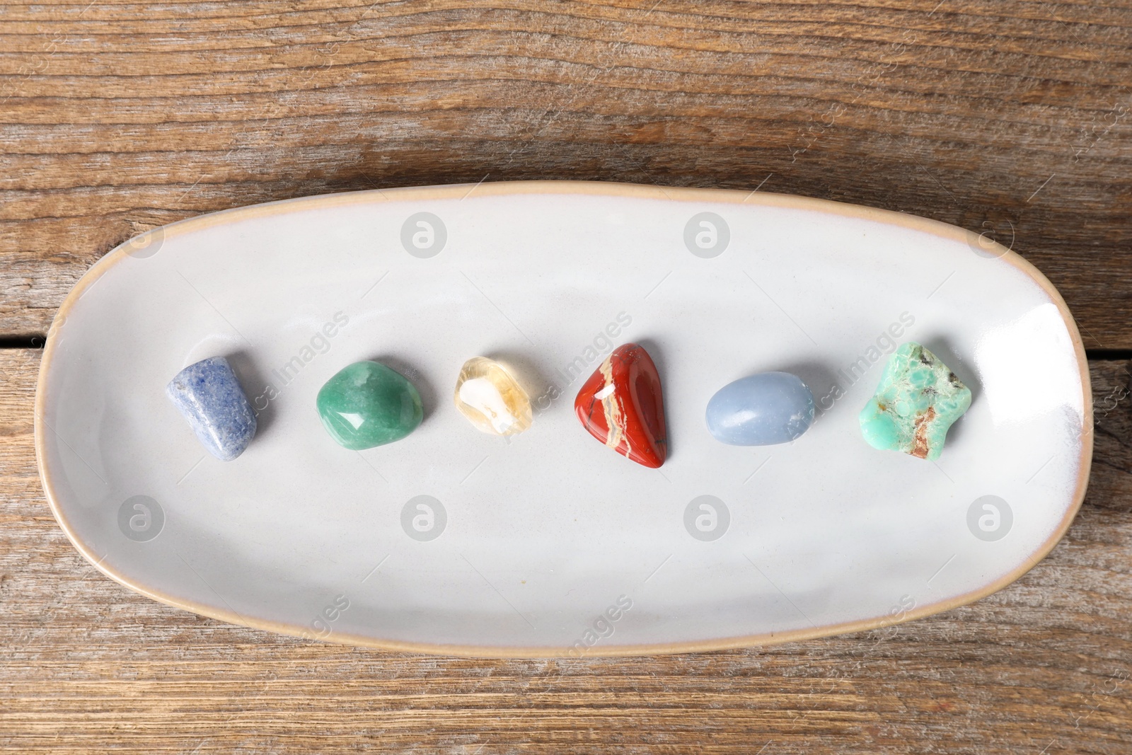 Photo of Aura. Different natural mineral stones on wooden table, top view