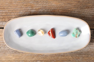 Photo of Aura. Different natural mineral stones on wooden table, top view