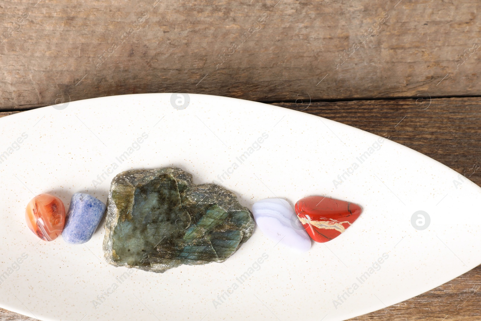 Photo of Aura. Different natural mineral stones on wooden table, top view