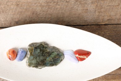 Photo of Aura. Different natural mineral stones on wooden table, top view