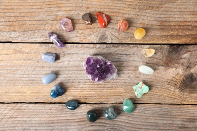 Photo of Aura. Different natural mineral stones on wooden table, flat lay