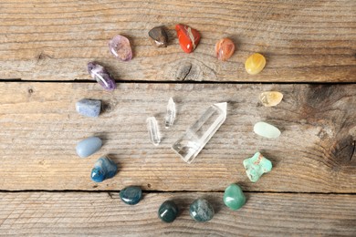 Photo of Aura. Different natural mineral stones on wooden table, flat lay