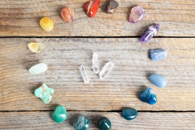 Photo of Aura. Different natural mineral stones on wooden table, flat lay
