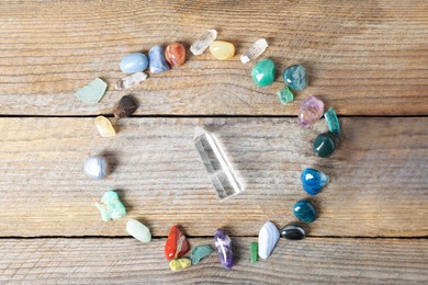 Photo of Aura. Different natural mineral stones on wooden table, flat lay