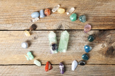 Photo of Aura. Different natural mineral stones on wooden table, flat lay