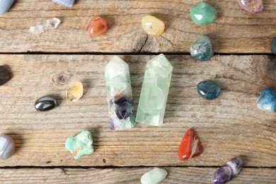 Photo of Aura. Different natural mineral stones on wooden table, flat lay