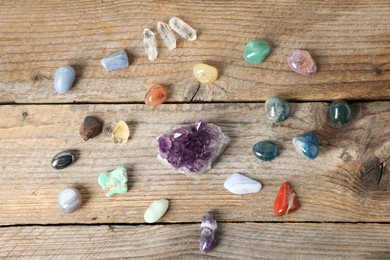 Photo of Aura. Different natural mineral stones on wooden table, flat lay