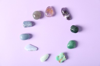 Photo of Aura. Different natural mineral stones on violet background, flat lay. Space for text