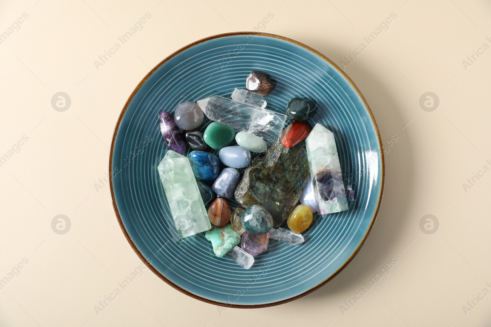 Aura. Different natural mineral stones on beige background, top view Photo of Aura. Different natural mineral stones on beige background, top view