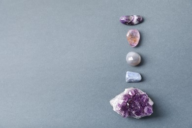 Photo of Aura. Different natural mineral stones on grey background, above view. Space for text