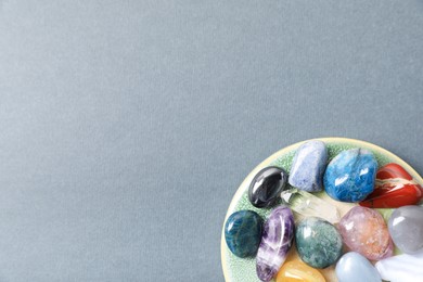 Photo of Aura. Different natural mineral stones on grey background, top view. Space for text