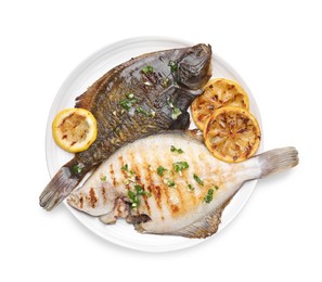 Photo of Tasty roasted flounder fish with herbs and lemon slices isolated on white, top view. Homemade seafood dish