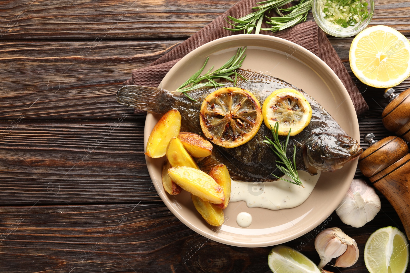 Photo of Homemade seafood dish. Tasty roasted flounder fish with rosemary, potato and lemon slices on wooden table, flat lay. Space for text