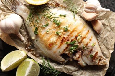 Photo of Tasty roasted flounder fish with spices on wooden table, flat lay. Homemade seafood dish