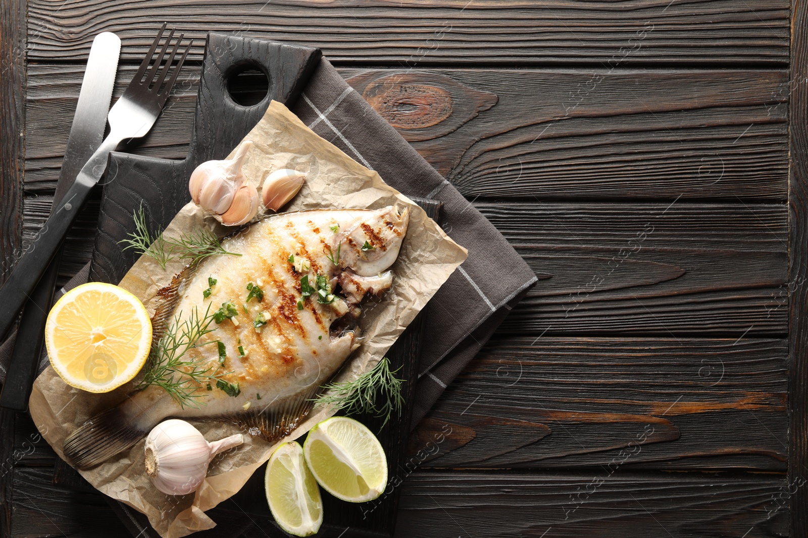 Photo of Homemade seafood dish. Tasty roasted flounder fish with spices served on wooden table, flat lay. Space for text