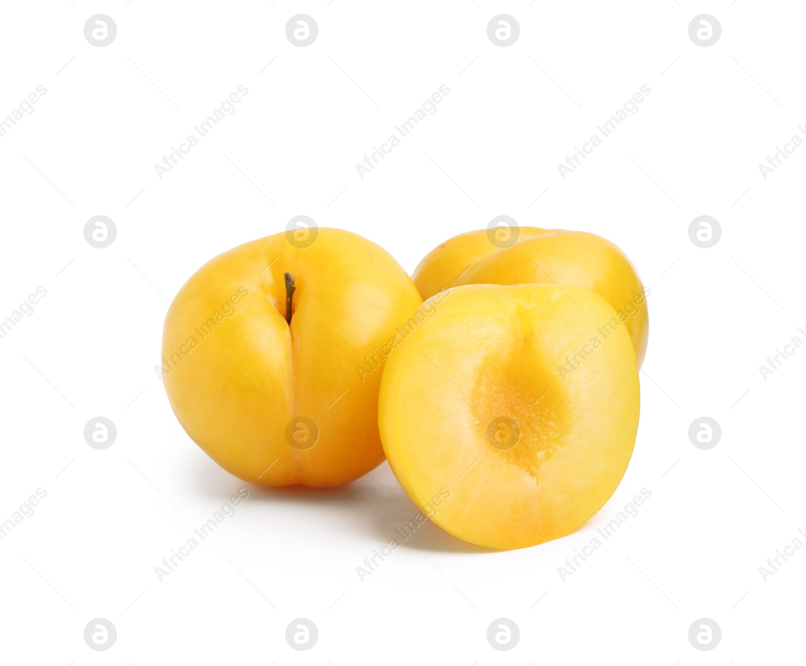 Whole and cut yellow cherry plums isolated on white Photo of Whole and cut yellow cherry plums isolated on white