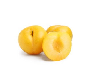 Photo of Whole and cut yellow cherry plums isolated on white