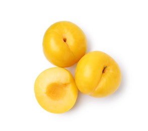 Photo of Whole and cut yellow cherry plums isolated on white, top view