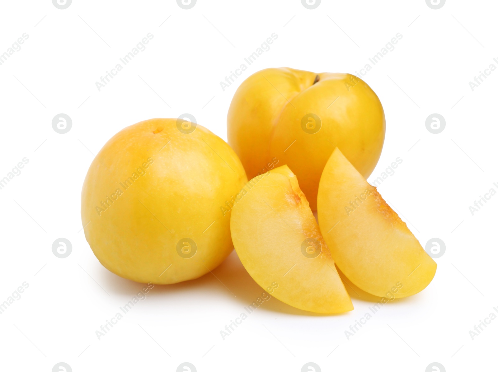 Whole and cut yellow cherry plums isolated on white Photo of Whole and cut yellow cherry plums isolated on white