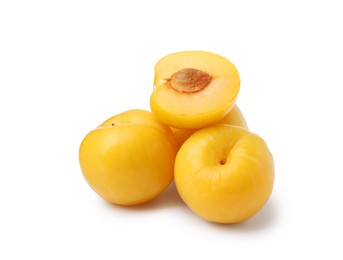 Photo of Whole and cut yellow cherry plums isolated on white