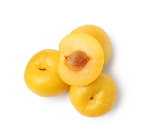 Photo of Whole and cut yellow cherry plums isolated on white, top view