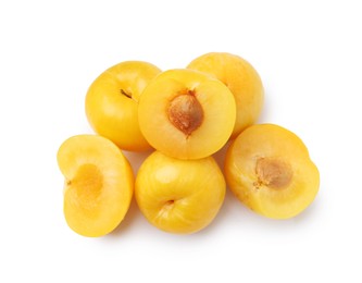 Photo of Whole and cut yellow cherry plums isolated on white, top view