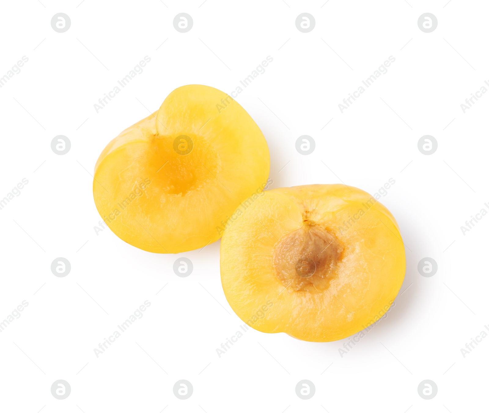 Halves of yellow cherry plum isolated on white, top view Photo of Halves of yellow cherry plum isolated on white, top view