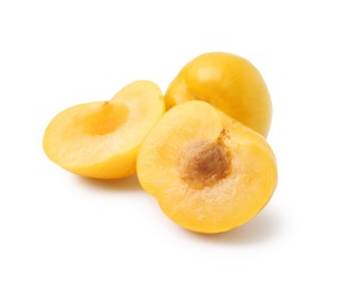 Photo of Whole and cut yellow cherry plums isolated on white