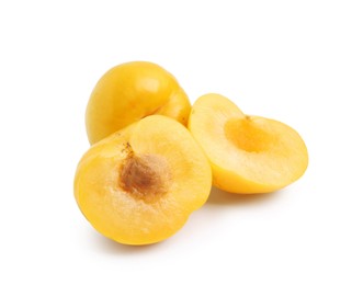 Photo of Whole and cut yellow cherry plums isolated on white