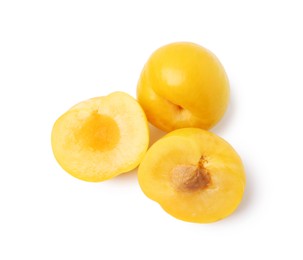 Photo of Whole and cut yellow cherry plums isolated on white, top view