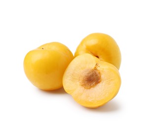 Photo of Whole and cut yellow cherry plums isolated on white