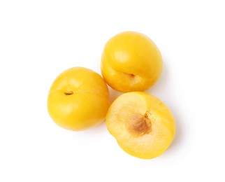 Photo of Whole and cut yellow cherry plums isolated on white, top view