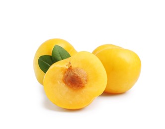 Photo of Whole and cut yellow cherry plums with leaves isolated on white