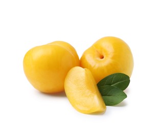 Photo of Whole and cut yellow cherry plums with leaves isolated on white
