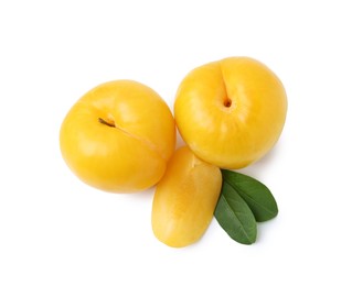 Photo of Whole and cut yellow cherry plums isolated on white, top view