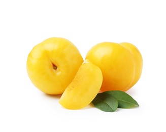 Photo of Whole and cut yellow cherry plums with leaves isolated on white