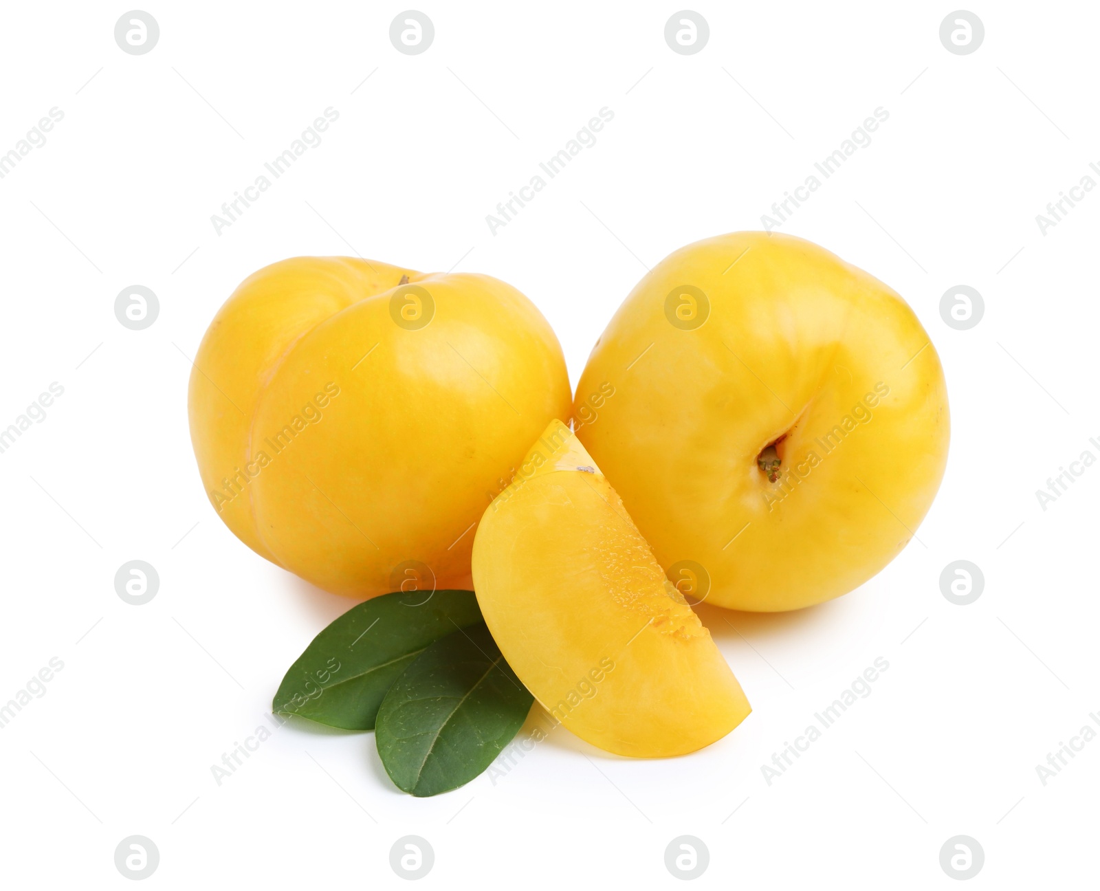 Whole and cut yellow cherry plums with leaves isolated on white Photo of Whole and cut yellow cherry plums with leaves isolated on white