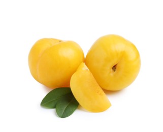 Photo of Whole and cut yellow cherry plums with leaves isolated on white