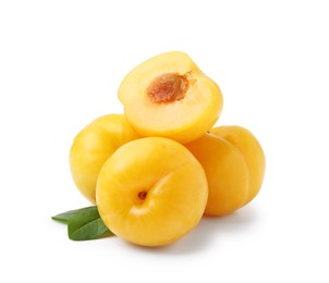 Photo of Whole and cut yellow cherry plums with leaves isolated on white