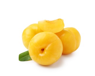 Photo of Whole and cut yellow cherry plums with leaf isolated on white