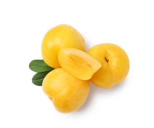 Photo of Whole and cut yellow cherry plums isolated on white, top view